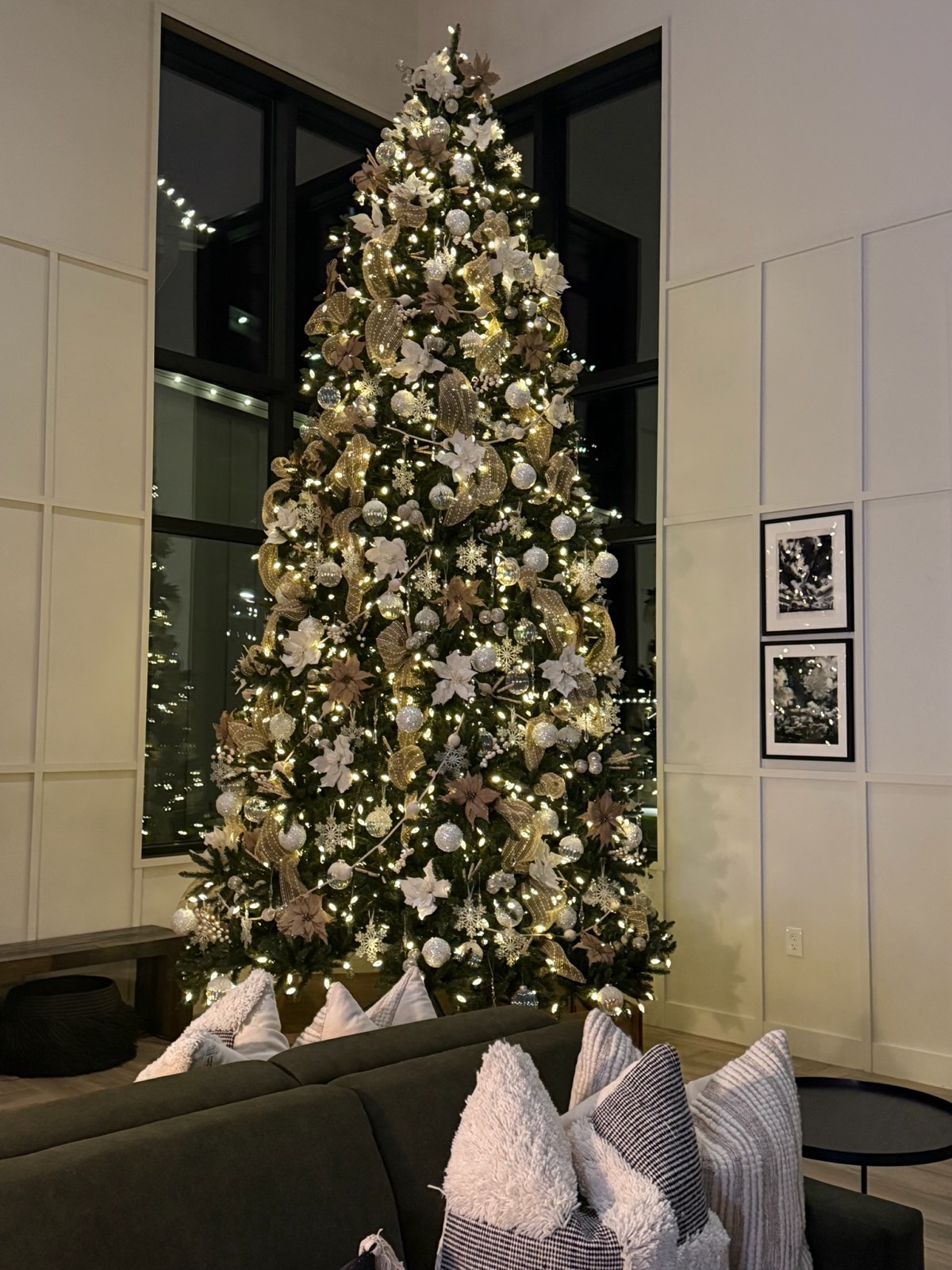 Christmas tree decorated by Black Oak Decor in champagne and gold, lit at night in an Austin living room