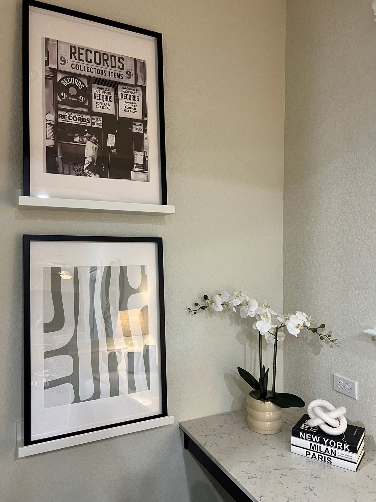Styled decor vignette with framed art and orchid